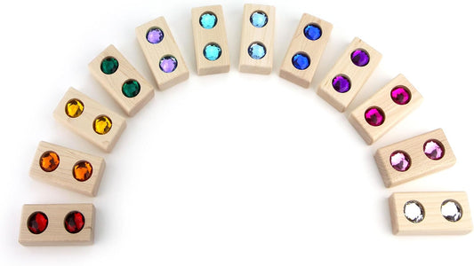 Twelve maple wooden blocks with rainbow acrylic gems inset, stacked in a row