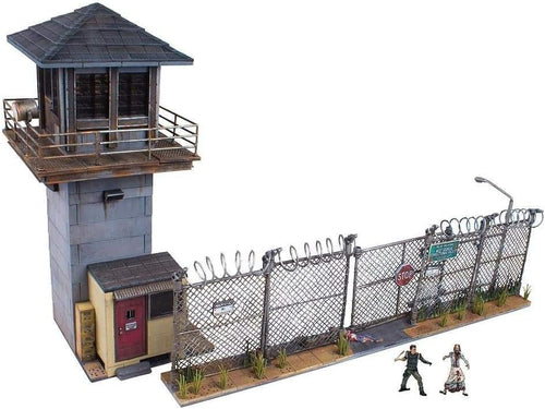 Brick-built prison guard tower and gate with barbed wire fence and zombie figures
