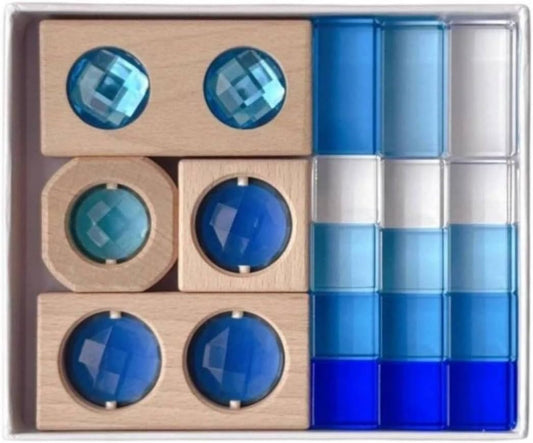 Wooden blocks with blue acrylic window insets and clear geometric shapes arranged in a tray