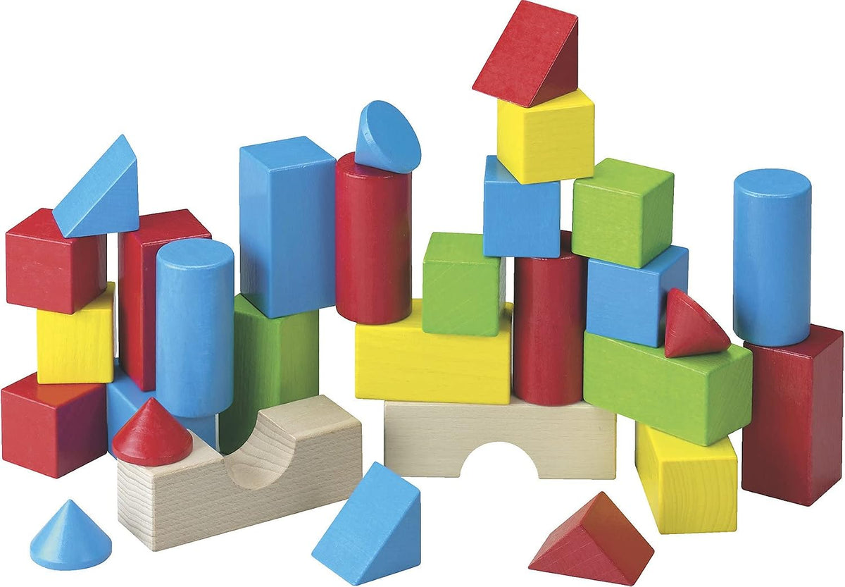Thirty colored beech wood blocks in rainbow shades stacked into a small town
