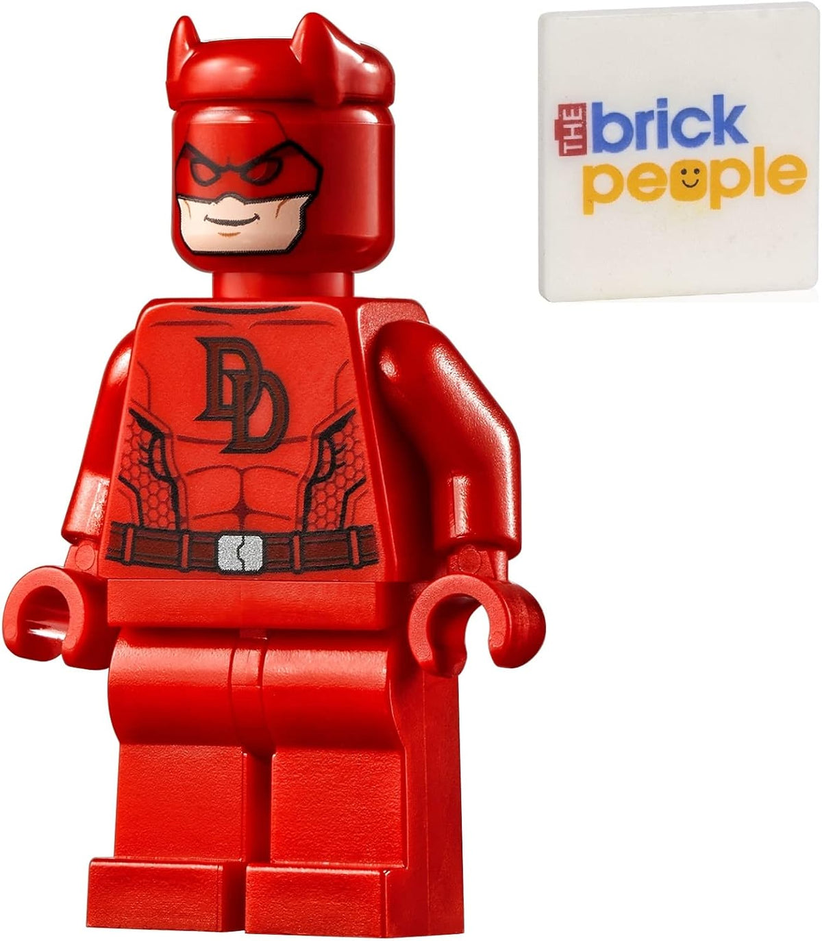 Red-suited superhero minifigure holding two batons beside a printed tile