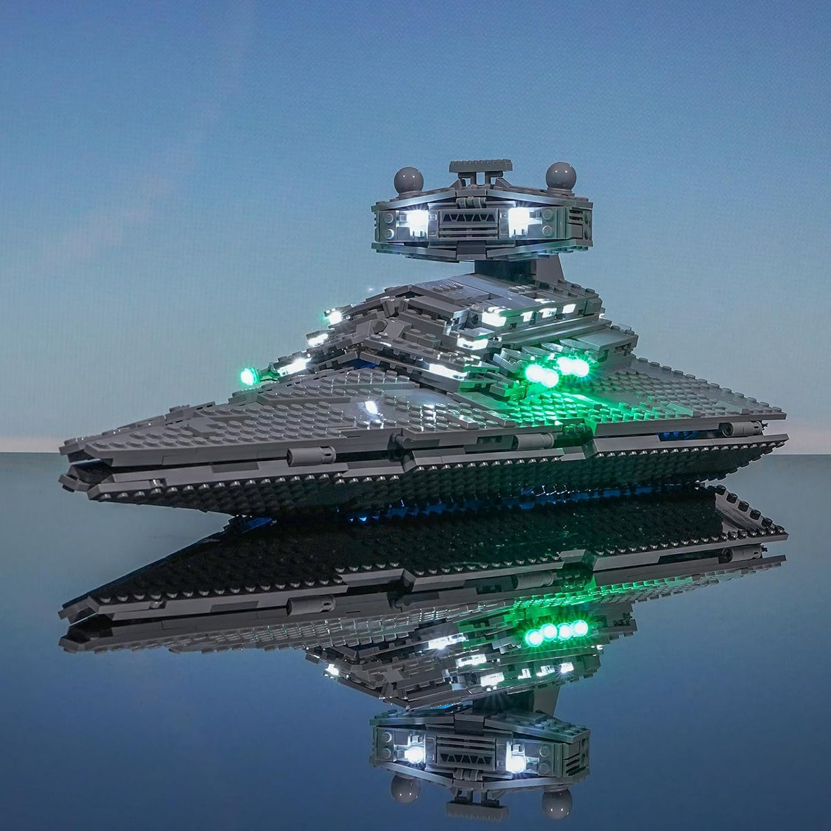 Large wedge-shaped gray brick warship glowing with blue LED engine lights