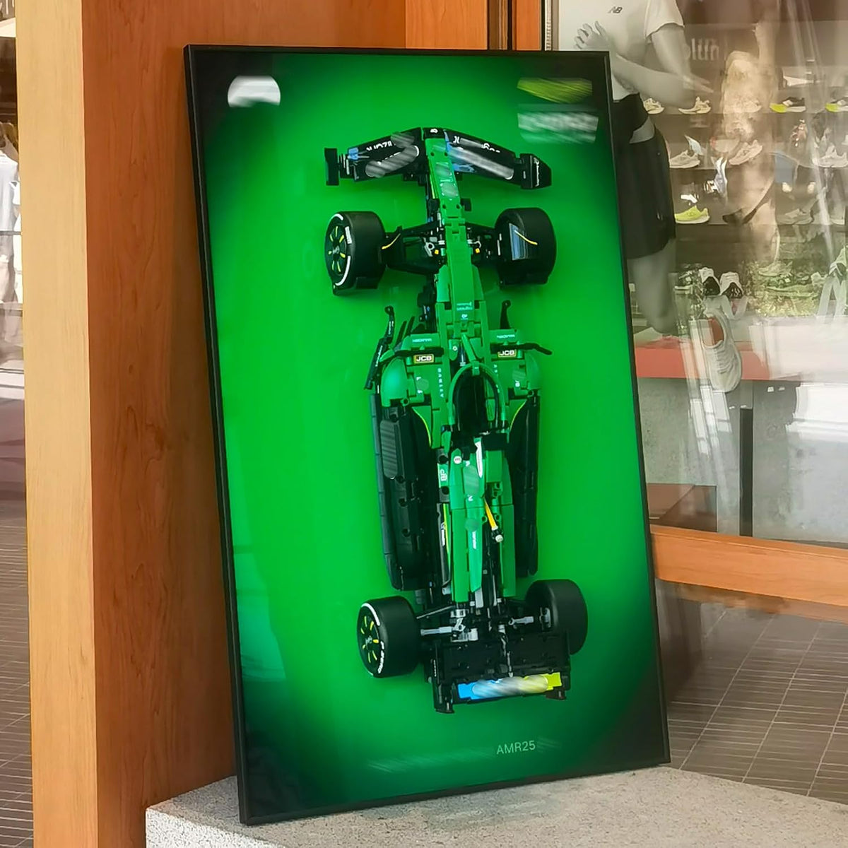 Wall-mounted display board holding an open-wheel race car brick model