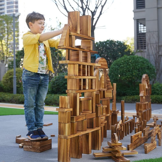 Jumbo carbonized wooden blocks stacked into a play structure in a yard