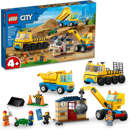 Brick-built yellow wrecking ball crane demolishing a small house beside a dump truck