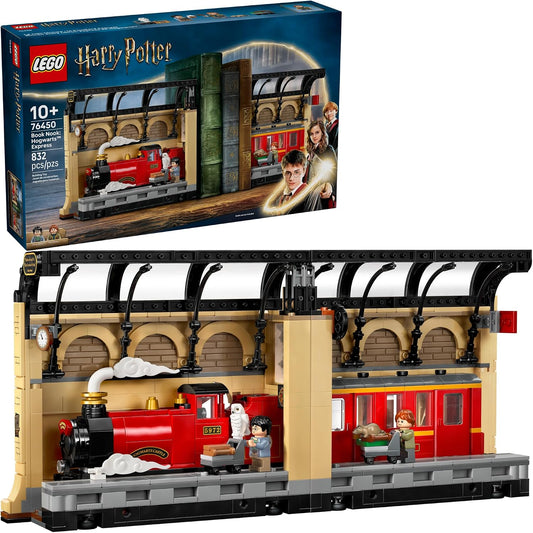 Red brick steam train at a station platform between books on a shelf