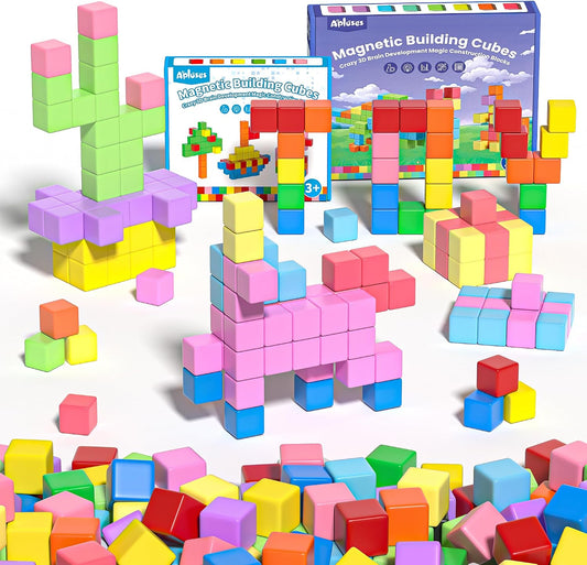 Colorful magnetic building blocks stacked into towers beside a storage bag
