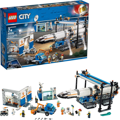 White brick-built rocket on a large crawler beside a control room and space rover